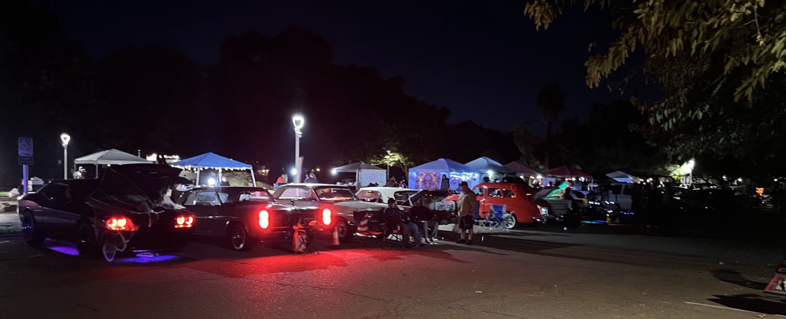 Food and merchandise vendor booths glowing at the Halloween event